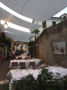 un restaurant avec des tables blanches et des parasols blancs dans l'établissement Dolce vita sur la colline de Turin, à Revigliasco