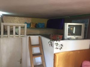 a room with a bunk bed and a tv and a ladder at Art Gallery Apartment in Skopje