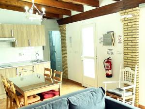 sala de estar con mesa y cocina en Casa piscina Privada Vallada & Barbacoa A&C, en Chiclana de la Frontera