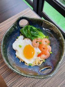 a plate of food with shrimp and eggs on a table at Cheeva Dee Hotel in Chiang Mai