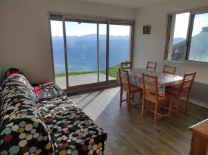ein Wohnzimmer mit einer Couch und einem Tisch und Stühlen in der Unterkunft Apartamento Pla d'adet Saint Lary in Saint-Lary-Soulan