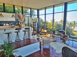 a kitchen and living room with large windows at Designer Villa with solar power at epic eco-beach in Umdloti