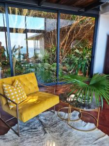 a living room with a yellow couch and a table at Designer Villa with solar power at epic eco-beach in Umdloti