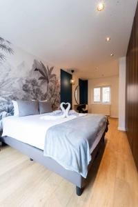 ein Schlafzimmer mit einem großen weißen Bett in einem Zimmer in der Unterkunft Luxury Duplex Coeur de Mons 64-3 in Mons