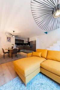 a living room with a yellow couch and a dining room at Luxury Duplex Coeur de Mons 64-3 in Mons