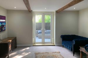 uma sala de estar com um sofá azul e uma porta de vidro deslizante em Croft House Cottage em Halifax