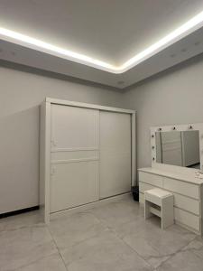 a room with white cabinets and a bench and a mirror at المسك للوحدات الفندقيه الفاخره in Al Madinah