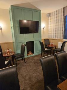 a waiting room with a fireplace and a flat screen tv at The Cotteridge Inn in Birmingham