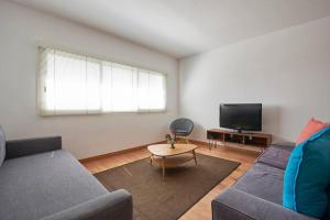 salon z kanapą i telewizorem w obiekcie Modern apartment in Parque das Nações w Lizbonie