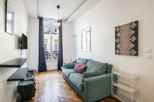 ein Wohnzimmer mit einem grünen Sofa und einem Tisch in der Unterkunft Pick A Flat's Apartements in Louvre-Rivoli - Rue du Roule in Paris