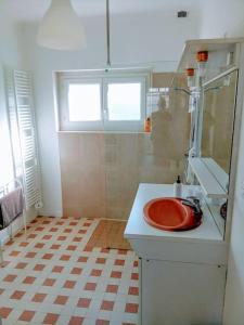 a bathroom with a red sink and a window at charmante maison près du centre ville in Amboise