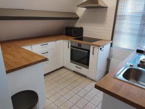 a small kitchen with white cabinets and a sink at Ontdek Brugge en Vlaanderen! in Zedelgem