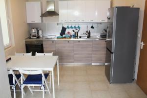 uma cozinha com uma mesa e um frigorífico em Lovely 1-bedroom apartment with pool, 250 m to the beach em Pomorie