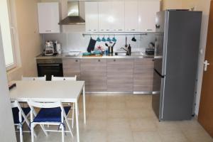 kuchnia ze stołem i lodówką w obiekcie Pomorie Residence 1-bedroom apartment with pool & free parking, 300 m to the beach w mieście Pomorie