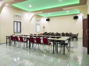 a conference room with a long table and chairs at RedDoorz Plus Syariah near Simpang Rimbo Jambi in Kinati