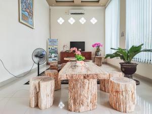 Habitación con mesa con taburetes y ventilador. en RedDoorz Plus Syariah near Simpang Rimbo Jambi, en Kinati