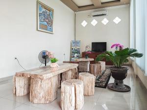 um quarto com uma mesa e alguns bancos de madeira em RedDoorz Plus Syariah near Simpang Rimbo Jambi em Kinati