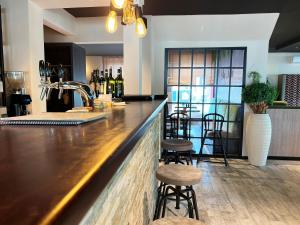 un bar con dos taburetes y una barra con botellas de vino en Hotel Da Toni en Neuenkirchen