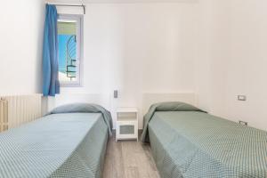 1 Schlafzimmer mit 2 Betten und einem Fenster in der Unterkunft Un sogno sul mare by BarbarHouse in Torre Pali 