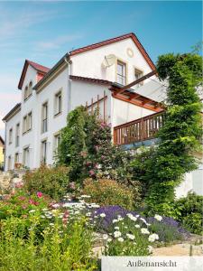 una casa blanca con flores delante en Landhaus Porschdorf en Porschdorf