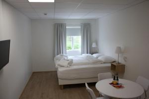 um quarto com uma cama, uma mesa e uma janela em AK Apartments em Akureyri
