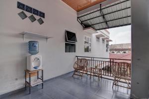 d'un balcon avec des chaises, une table et une télévision. dans l'établissement OYO 92806 Penginapan Geby Syariah, à Pekanbaru