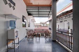 - un balcon avec des chaises et une table dans un bâtiment dans l'établissement OYO 92806 Penginapan Geby Syariah, à Pekanbaru