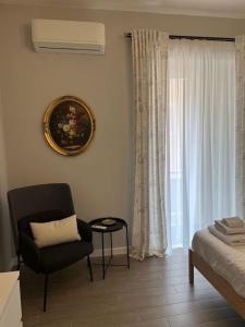 uma sala de estar com uma cadeira e uma janela em Civico63 em Agrigento