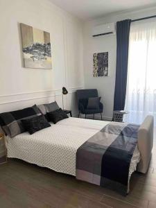 um quarto com uma cama, uma cadeira e uma janela em Civico63 em Agrigento