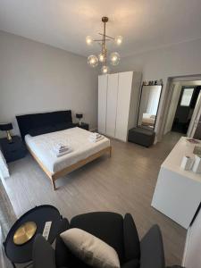 um quarto com uma cama e cadeiras e um lustre em Civico63 em Agrigento