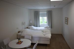 a bedroom with a bed and a table and chairs at AK Apartments in Akureyri +3 photos