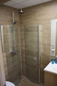 um chuveiro com uma porta de vidro na casa de banho em AK Apartments em Akureyri