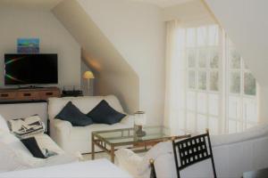 uma sala de estar com um sofá branco e uma mesa de vidro em Albatros D2 em De Haan