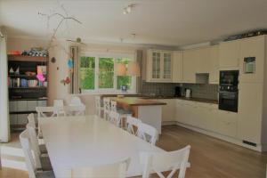 een keuken met een witte tafel en witte stoelen bij Summer Dream in De Haan