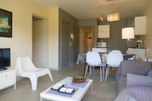 een woonkamer met een bank, stoelen en een tafel bij Green Garden XV 0004 in De Haan