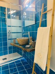 a blue tiled bathroom with a sink and a shower at Da Ida in Bosa