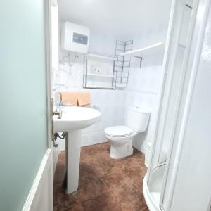 La salle de bains blanche est pourvue de toilettes et d'un lavabo. dans l'établissement Casa Mami Carmen Telde, Las Palmas, à Balcon de Telde