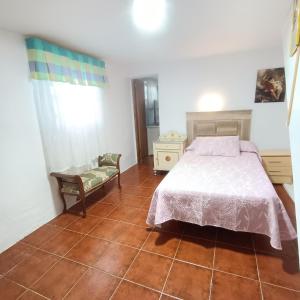 - une chambre avec un lit et une chaise dans l'établissement Casa Mami Carmen Telde, Las Palmas, à Balcon de Telde