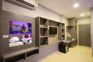 a bedroom with a tv on the wall and a bed at KRABI CHARM in Ban Khlong Haeng