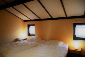 een slaapkamer met 2 witte bedden en 2 ramen bij Zeewind I 46 in Bredene