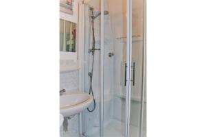 een badkamer met een douche en een wastafel bij Achter N Diek in De Haan