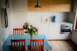 una cocina con una mesa con un jarrón de flores. en Zeewind II 112, en Bredene