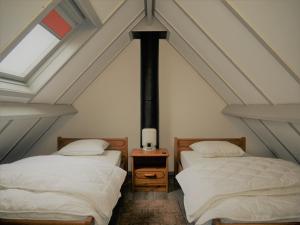 two beds in a attic room with a window at Zeepolder I 3 in De Haan +9 photos