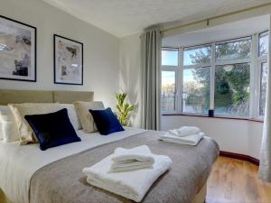 a bedroom with a large bed with towels on it at Terracotta House I Executive House I Parking and Pet Friendly I eco-Short Term Let by SILVA in Clapham