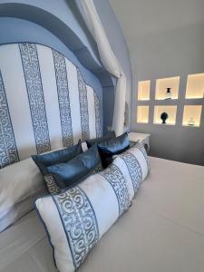 een bed met blauwe en witte kussens in een kamer bij Hotel Marincanto in Positano