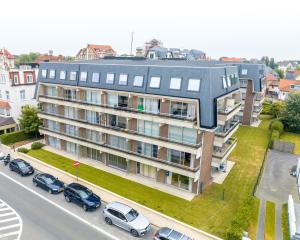 an apartment building with cars parked in front of it at Lilyta B303 in De Haan