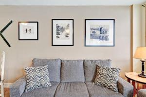 ein Wohnzimmer mit Sofa und vier Bildern an der Wand in der Unterkunft River Run Village Condominiums in Keystone