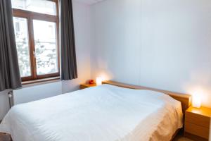 um quarto com uma cama branca e uma janela em Beau Sejour A1 em De Haan