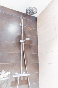 una ducha con cabezal de ducha en un baño en Beau Sejour A1, en De Haan