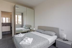 een slaapkamer met 2 handdoeken op een bed met een spiegel bij IM HOME - NAPO TORRIANI STAZIONE CENTRALE in Milaan